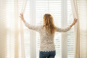 Woman opening window shutters