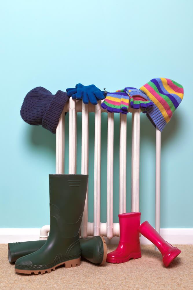 hats and wellies drying by a radiator