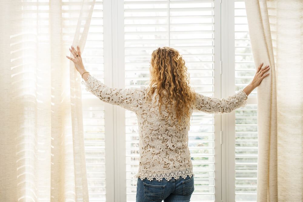 lady opening curtains