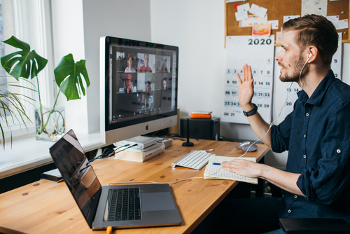 Young man having Zoom video conferencing call via computer. Home office.