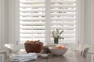 white window shutters next to a dining table