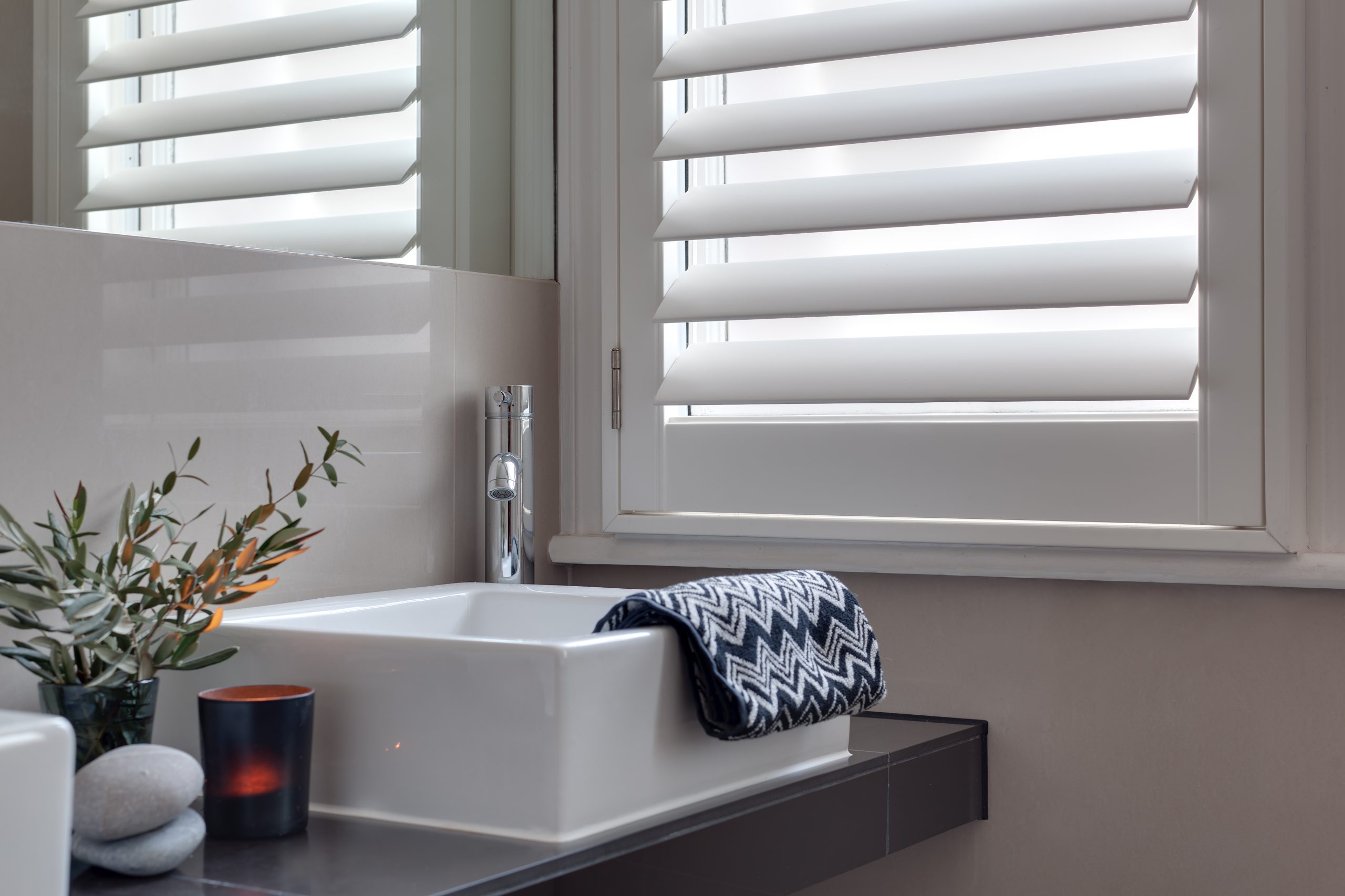 Bathroom detail with Salcombe waterproof shutters and a white sink.