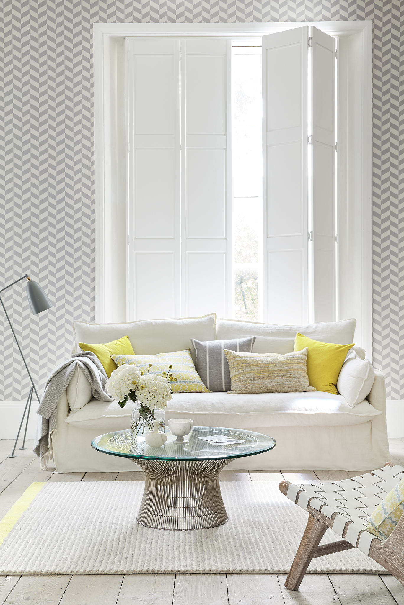 Solid shutters in a modern living room with white and yellow colour tones .