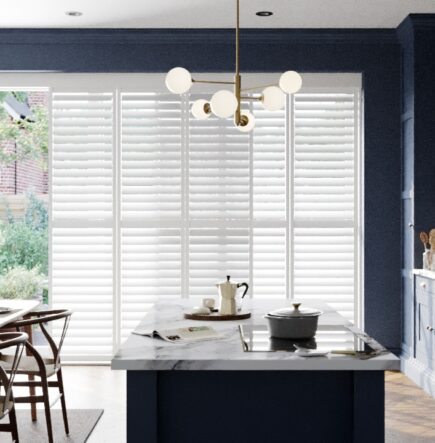 White shutters on patio doors in blue kitchen