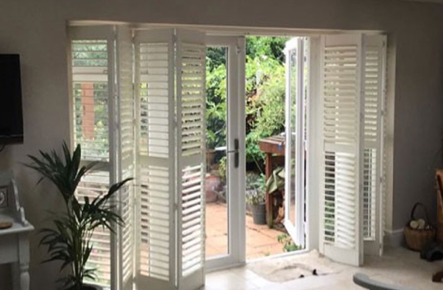 white patio shutters leading out to garden