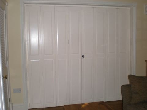 Closed solid full-height window shutters in white colour with narrow panels.