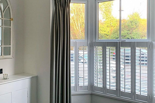 White café style shutters on a bay window facing the road